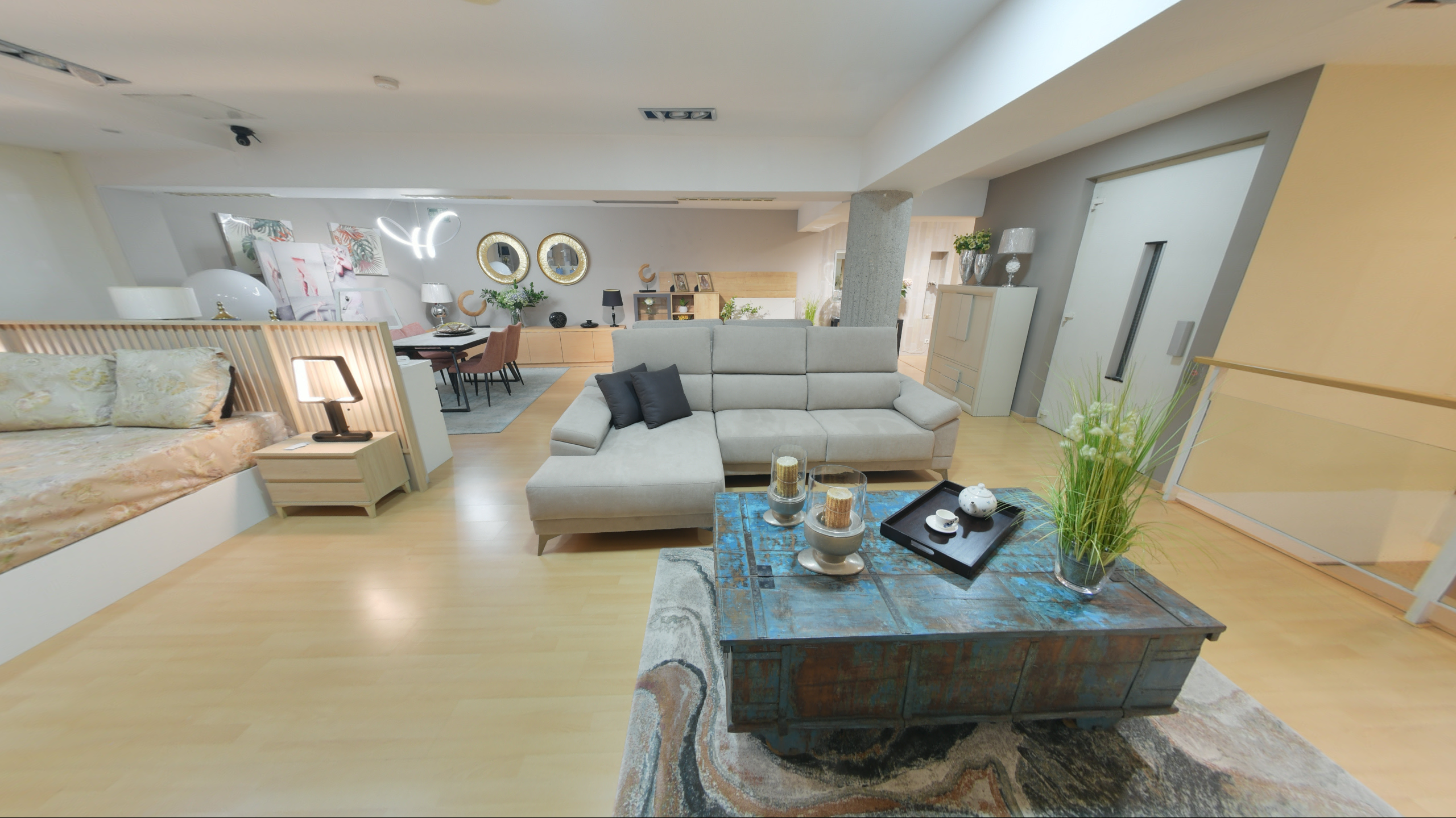 Tienda de Muebles en Barcelona, mobiliario a medida y diseño - Temas Mobiliario Sofá chaise longue de color gris claro frente a una mesa de centro rústica azul turquesa en un ambiente de salón contemporáneo.